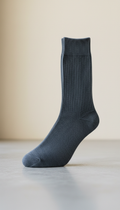 A perfectly centered shot of sophisticated socks in 'Slate Gray', using a 50mm lens for a natural perspective. The socks...