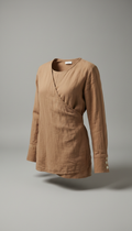 A warm taupe shirt from Nature's Canvas is displayed against a pebble grey background. The shirt is positioned at a 3/4...