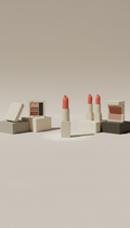 Soft coral lipstick stick, Three-quarter product angles on compact blocks matching the brand’s neutral palette; products...