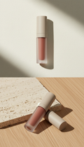 Modern Glow Lip Tint, Hero product shots at a clean 3/4 angle on tactile surfaces (stone slab or matte wood), with soft...