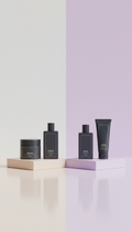 Deep charcoal barber grooming essentials pack, Three-quarter angle hero shots on mirrored or lacquered risers with...